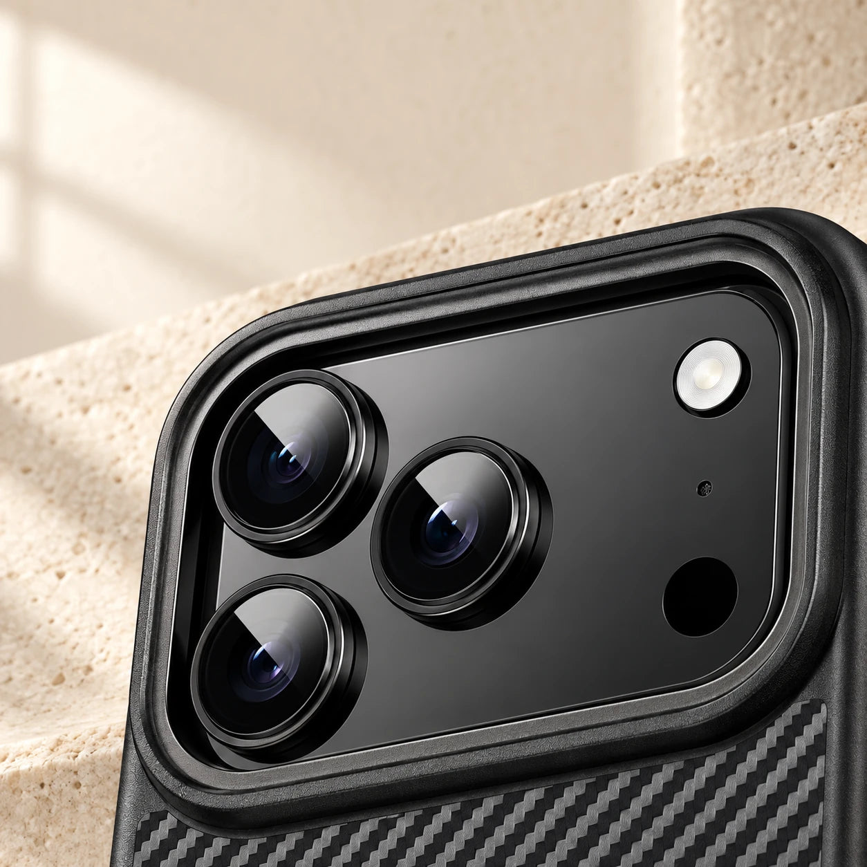 Close-up of the raised black camera surround on a carbon-pattern phone case.