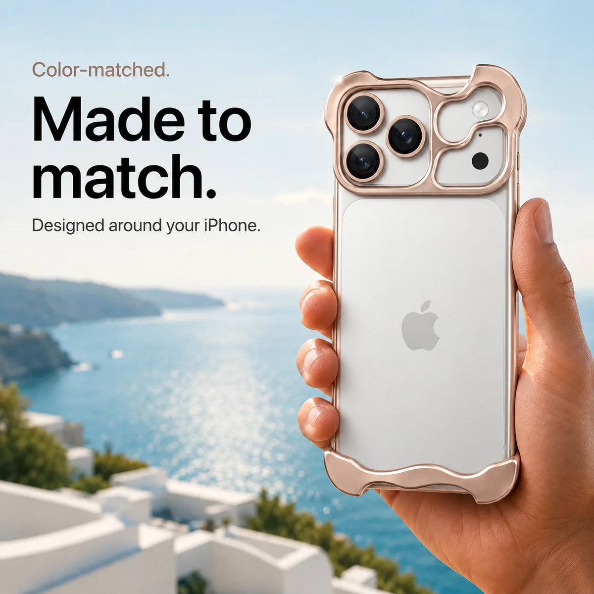Champagne gold sculpted metal phone case held in a hand above a coastal background #color_Champagne Gold