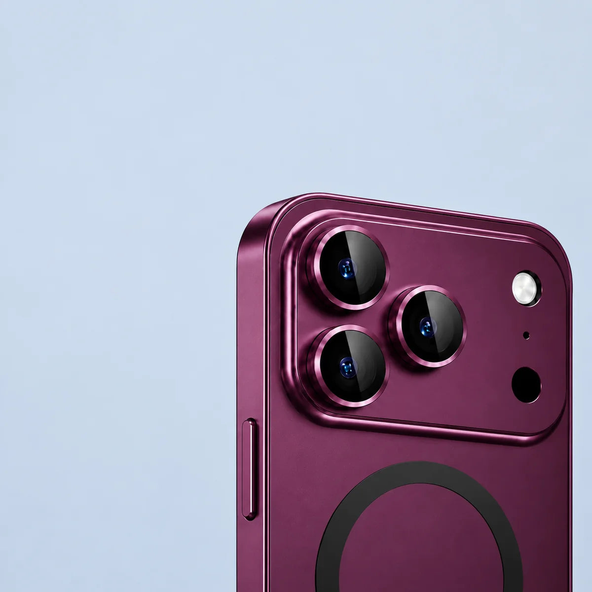 Close-up of the raised dark cherry metal guards around three rear camera lenses.