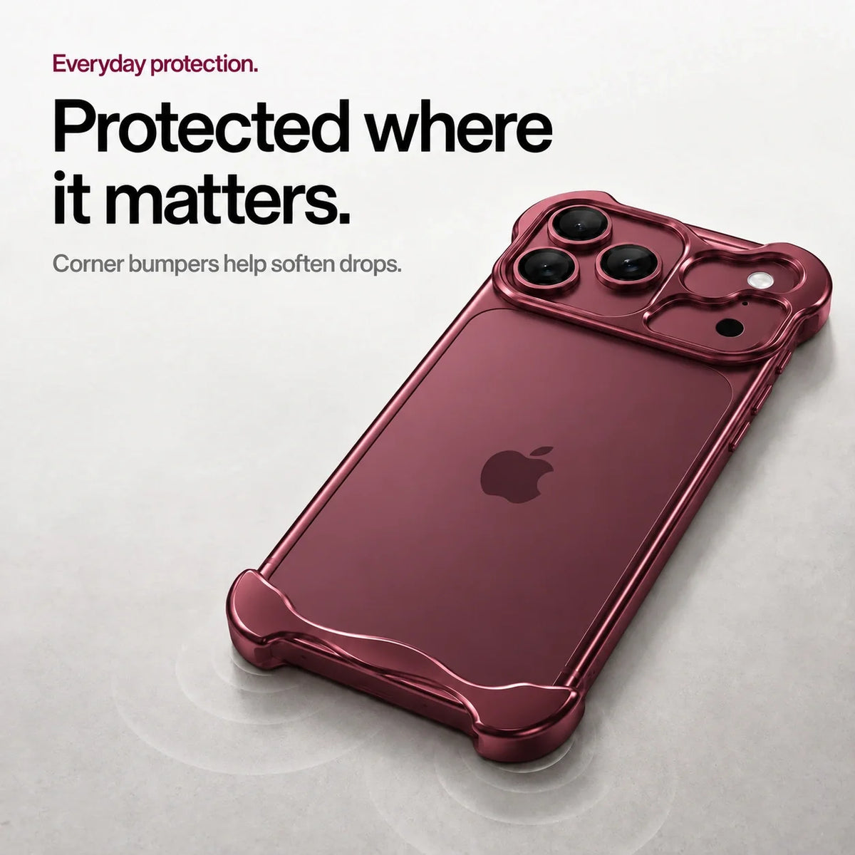 Burgundy sculpted metal phone case on a desk showing its corner bumpers #color_Burgundy