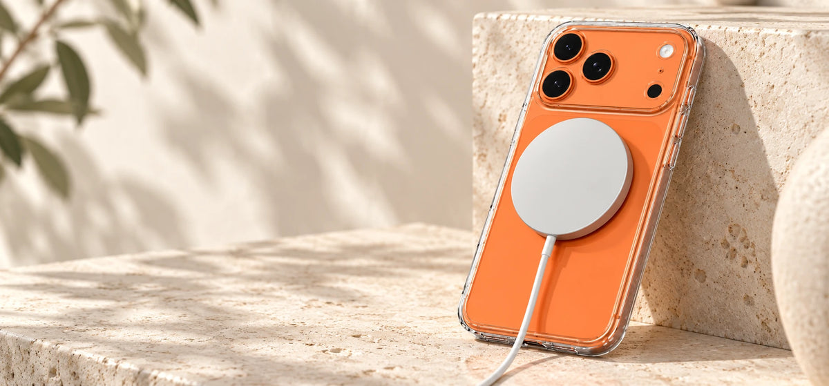 White magnetic charging puck attached to a clear case on an orange phone.