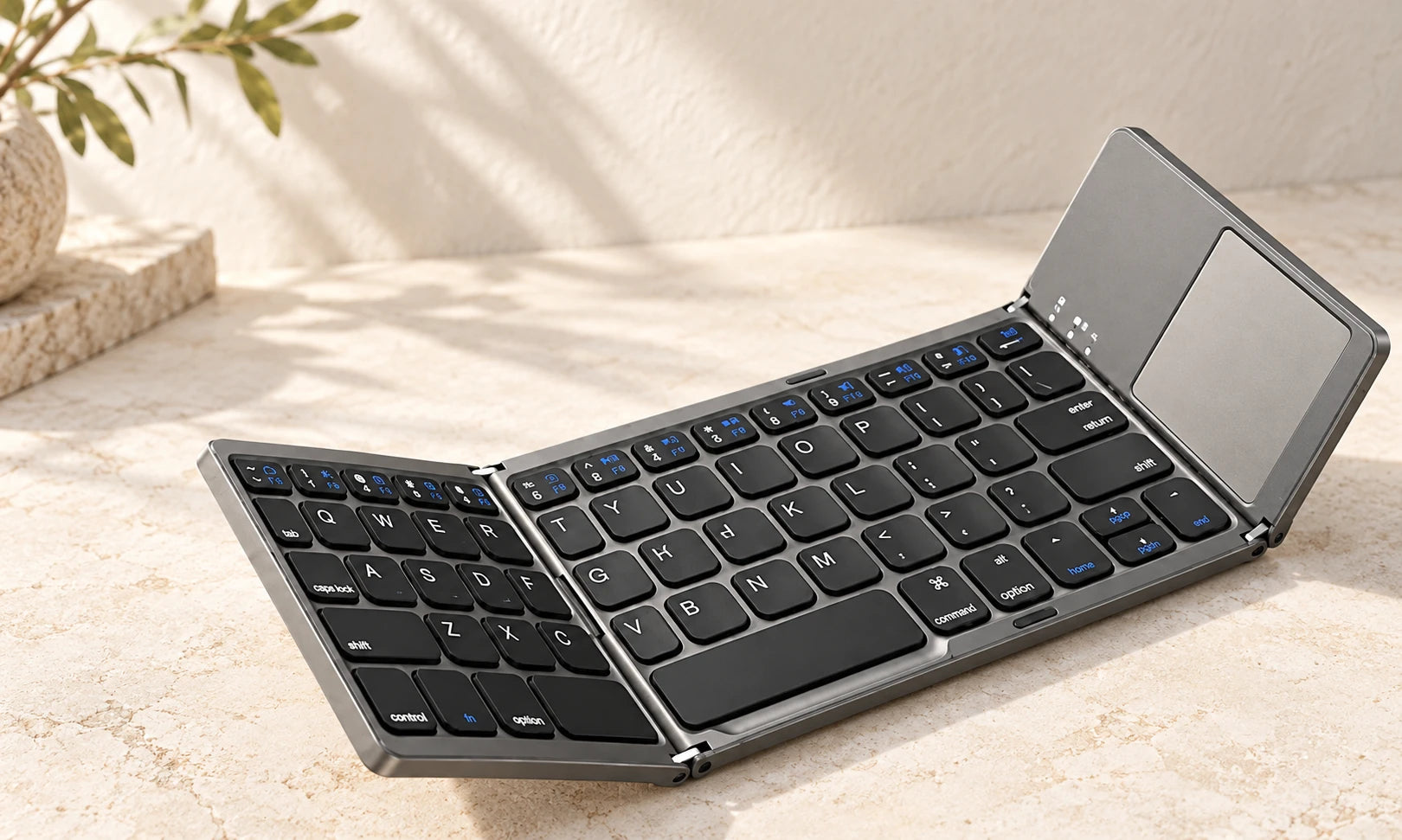 Close-up of a gray folding keyboard hinge and black keys.